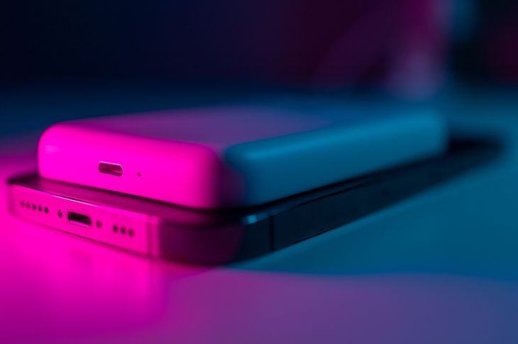 Iphone ja magsafe akupank roosas valguses.
