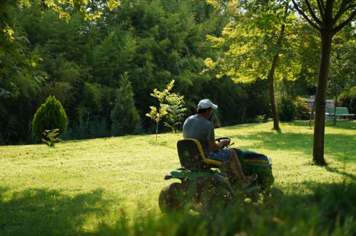 mees niidab John Deere murutraktoriga muru