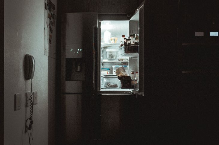Lahtise üksega külmik valgustab pimedat kööki.
