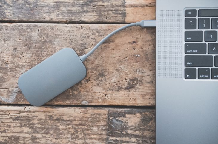 Macbook pro on ühendatud hõbedase kompaktse välise kõvakettaga.