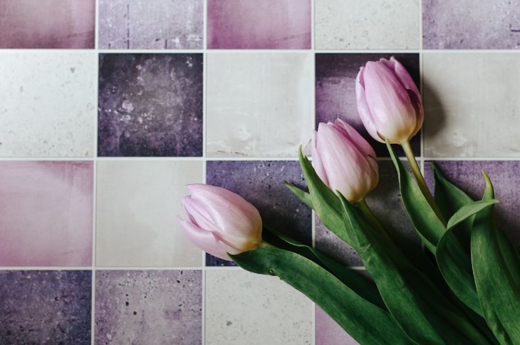 violetsed tulbid mosaiikplaadi taustal